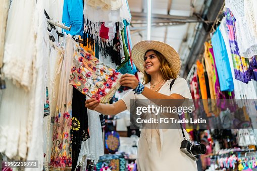 Young woman looking clothes at market Young woman looking clothes at market