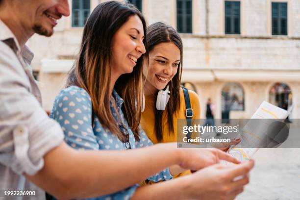 three young friends reading a map on the street in dubrovnik - stone town stock pictures, royalty-free photos & images