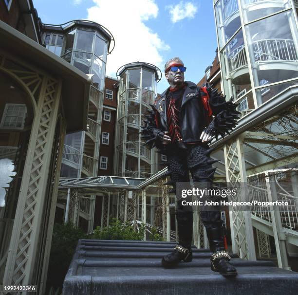 English interior designer Nicky Haslam posed wearing an exotic spiked outfit incorporating a sleeveless leather jacket, in London circa 1986.