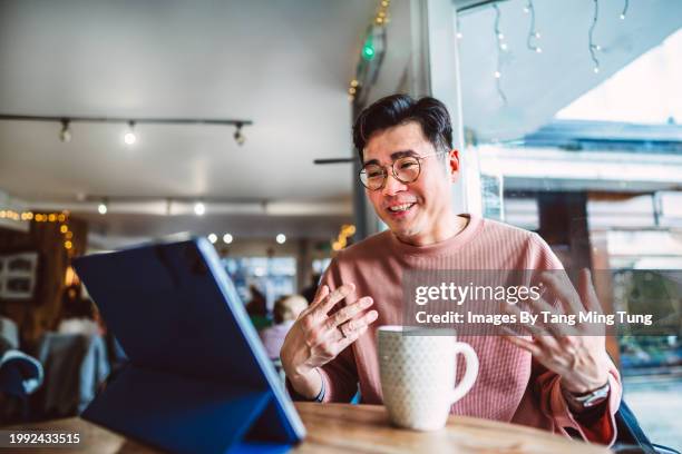 confident businessman having a video conference call on digital tablet while having coffee break in cafe. the concept of remotely working. - public building stock pictures, royalty-free photos & images