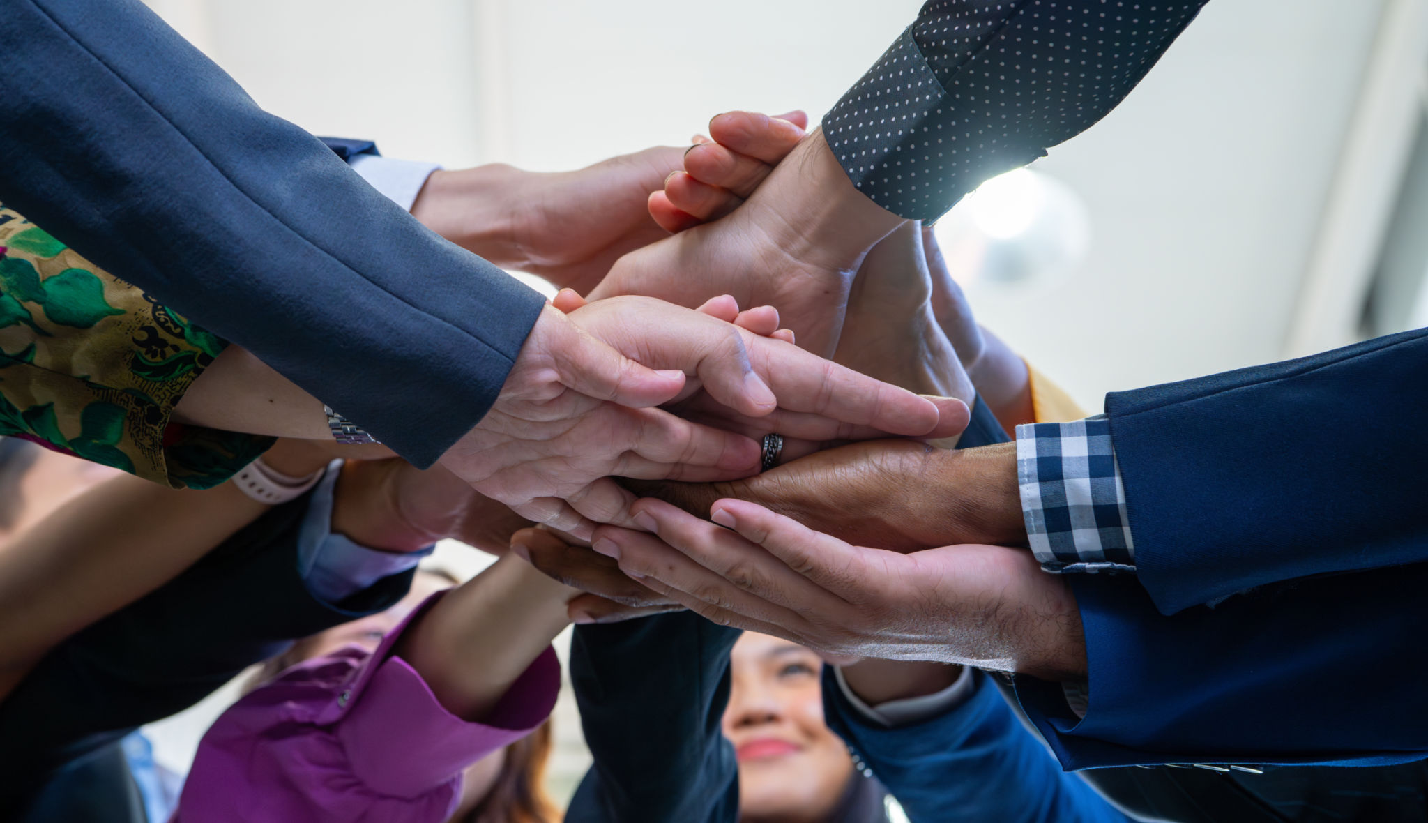 Team, teamwork, and unity concept. Diverse team putting hands together. Group of diverse business people. Working together as a team. Partnership and togetherness create a strong sense of community. Team, teamwork, and unity concept. Diverse team putting hands together. Group of diverse business people. Working together as a team. Partnership and togetherness create a strong sense of community.