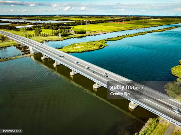 traffic driving over a bridge over a lake in a nature reserve - ヘルダース・アイセル川 ストックフォトと画像