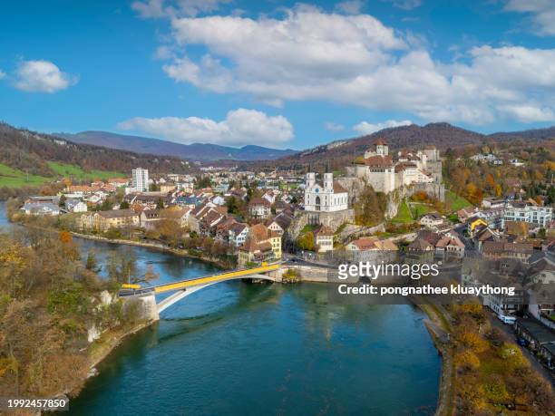 flight over the aare river in aarburg city switzerland. autumn aerial drone shot rotating around the church and fortress of the town of aarburg in switzerland. aerial view of landmarks aarburg castle. - aarau stockfoto's en -beelden