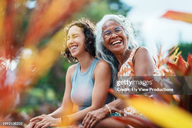 une femme des îles du pacifique et sa fille adulte eurasienne passent du temps ensemble à l’extérieur - habitant-des-îles-du-pacifique photos et images de collection