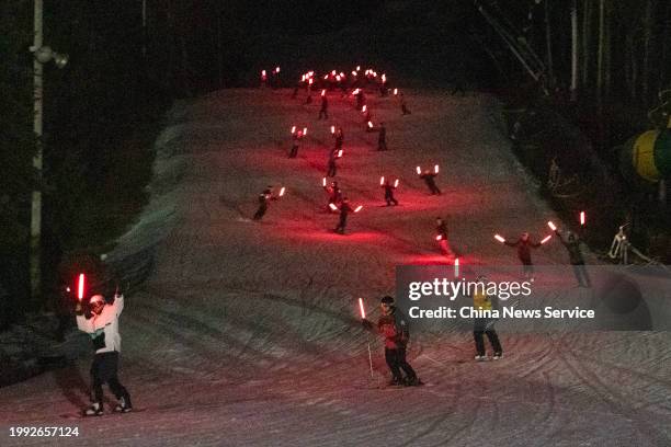 Skiers perform a light show at night in Camelback Mountain Resort to welcome the upcoming Chinese New Year, the Year of the Dragon, on February 6,...