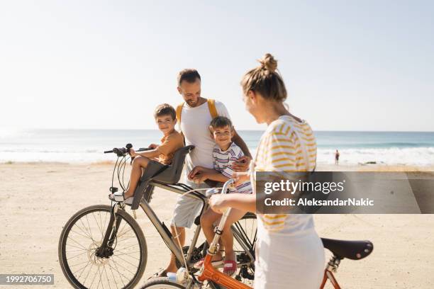 giovane famiglia che va in bicicletta in estate - famiglia con due figli foto e immagini stock