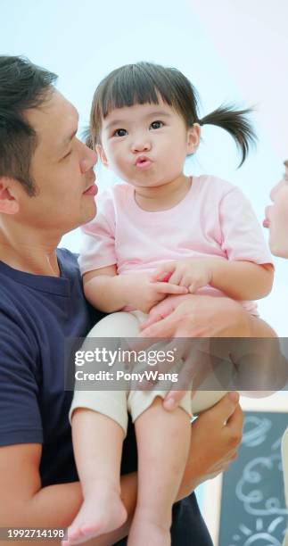 asian parent kiss little girl - accompanying stock pictures, royalty-free photos & images