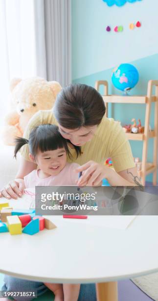 asian mother painting with kid - accompanying stock pictures, royalty-free photos & images