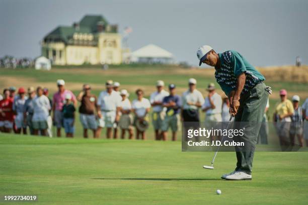 Spectators look on as Tiger Woods from the United States follows his putt to the hole during the United States Amateur Championship golf tournament...