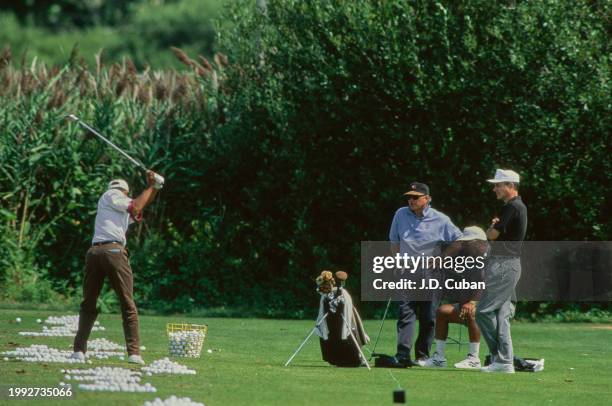 Tiger Woods from the United States with golf coach Butch Harmon reviewing his golf swing technique as father Earl Woods and caddy Jay Brunza look on...