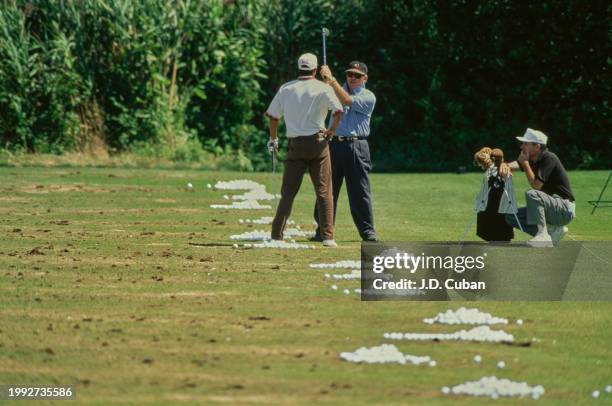 Tiger Woods from the United States in conversation with golf coach Butch Harmon reviewing his golf swing technique during practice for the United...