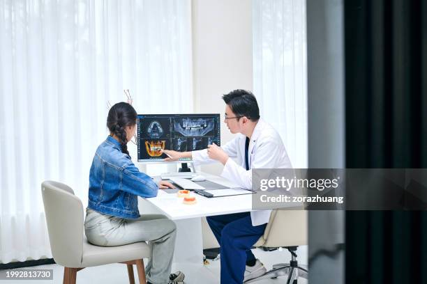 asian dentist and female patient discussing at dental office - implante dentário imagens e fotografias de stock