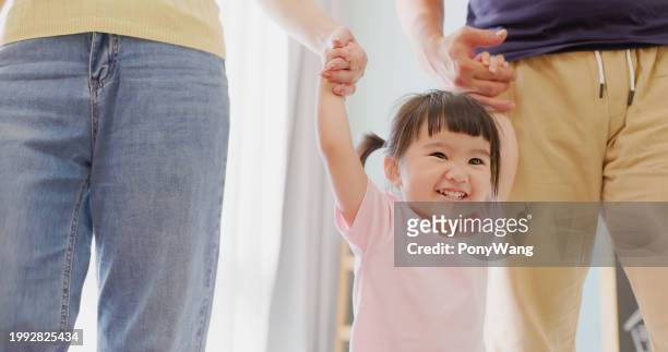 parent lead kid learning walk - accompanying stock pictures, royalty-free photos & images