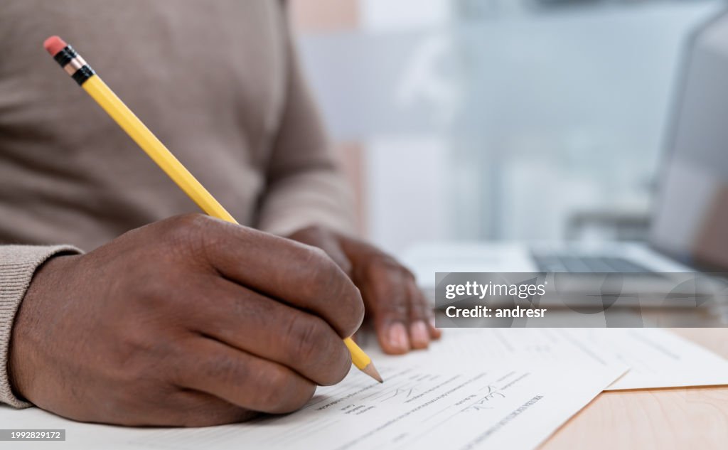 Close-up on a teacher grading exams in the classroom