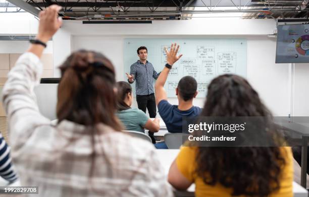 students asking question to the teacher in an it class - ensino superior imagens e fotografias de stock