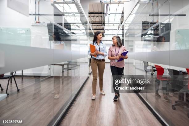 des enseignantes heureuses discutent dans le couloir de l’université - master class photos et images de collection