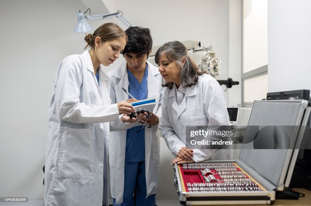 Ophthalmologist teaching medical students how to use some optical instrument