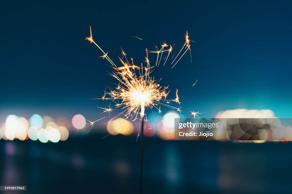 Burning sparkler against sky