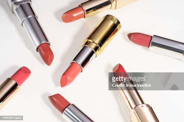 pattern made of red beige pale brown lipstick lip on white background. - red lipstick swatch stock pictures, royalty-free photos & images