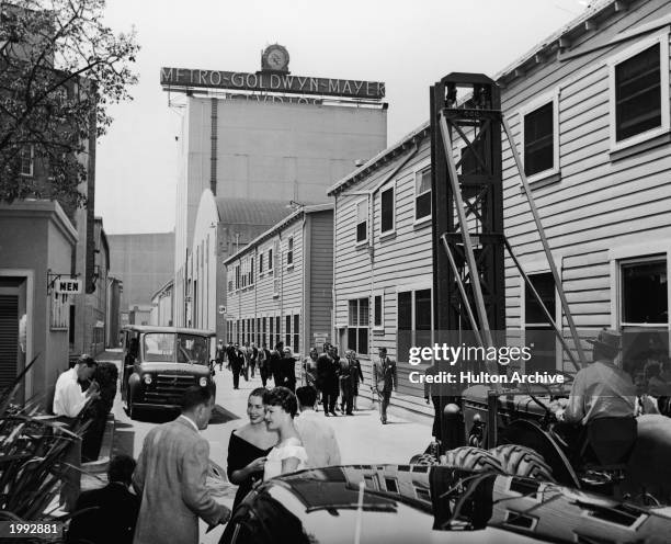 Man moves machinery and sets as groups of people walk down the main thoroughfare of MGM Studios, Hollywood, California, circa 1945.