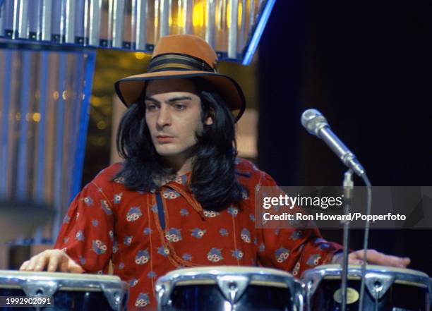 Percussionist Mickey Finn performs on stage with English rock band T Rex on the set of a pop music television show in London circa 1972.