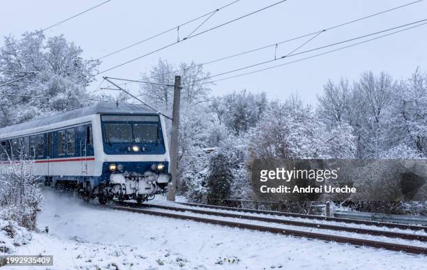 passenger train traveling through snow, in nature, in germany - stuttgart village stock pictures, royalty-free photos & images