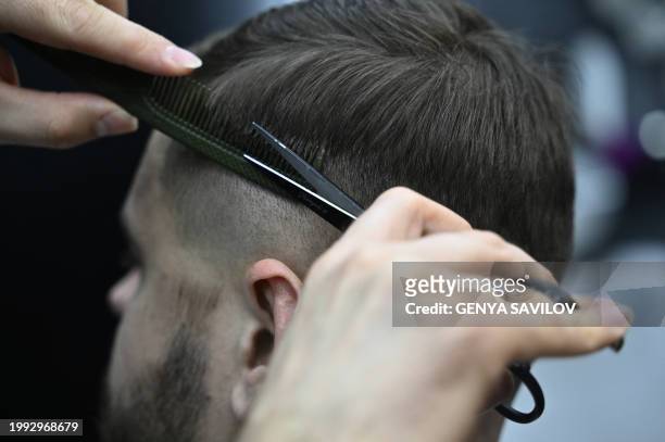 Barber cuts the hair of a customer in a barber shop in the town of Kramatorsk, Donetsk region on February 9 amid the Russian invasion of Ukraine.