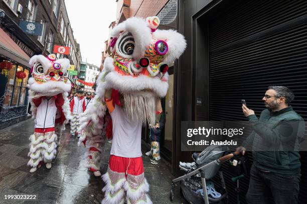 Dancers in traditional Lion costumes perform among the crowds in Chinatown in celebration of the arrival of the Year of the Dragon in London, United...