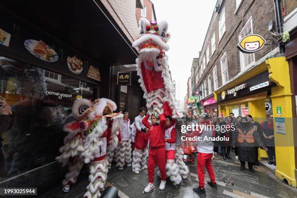 Dancers in traditional Lion costumes perform among the crowds in Chinatown in celebration of the arrival of the Year of the Dragon in London, United...