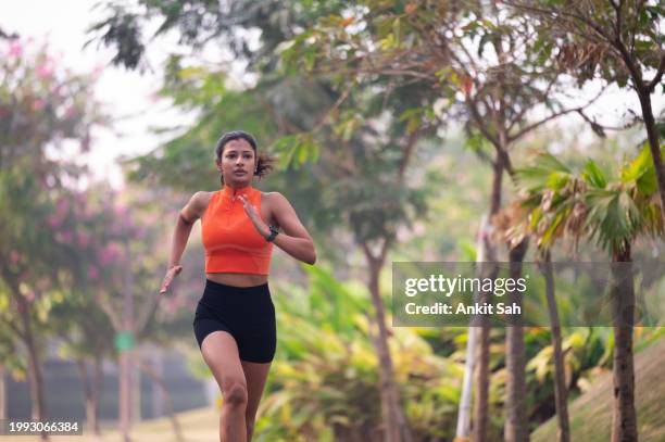 young fitness woman running on the park. the concept of a healthy lifestyle stock photo - sport determination stock pictures, royalty-free photos & images