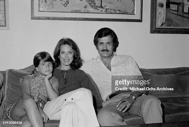 American actress Jennifer Aniston with her mother, American actress Nancy Dow and father, Greek-born American actor John Aniston, sitting on a sofa...