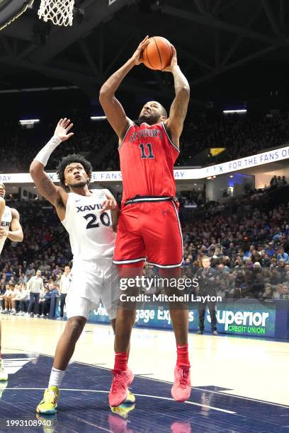 Joel Soriano of the St. John's Red Storm takes a shot over Dayvion McKnight of the Xavier Musketeers during a college basketball game at the Cintas...