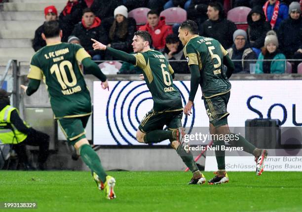 Robin Gosens of 1.FC Union Berlin celebrates scoring his team's first goal with teammates Danilho Doekhi and Kevin Volland during the Bundesliga...