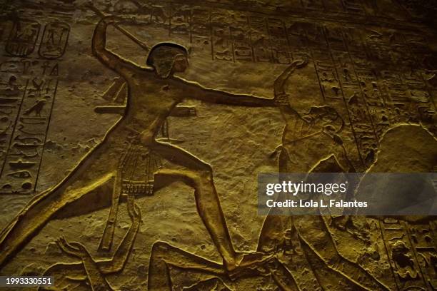 ancient egyptian bass relief representing the pharaoh in battle defeating his enemies. great temple of ramses ii, abu simbel, aswan, egypt - ancient egyptian culture stock pictures, royalty-free photos & images