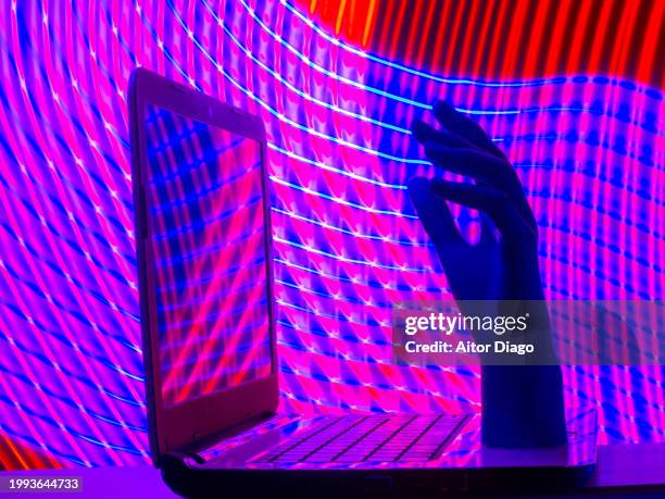 human hand comes out of a laptop computer. artificial intelligence concept - writing code stock pictures, royalty-free photos & images