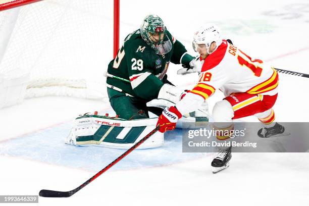 Marc-Andre Fleury of the Minnesota Wild defends his net against A.J. Greer of the Calgary Flames in the third period at Xcel Energy Center on January...