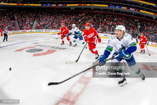 Brock Boeser of the Vancouver Canucks dumps the puck past Patrick Kane of the Detroit Red Wings during the first period at Little Caesars Arena on...