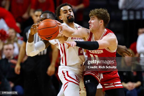 Max Klesmit of the Wisconsin Badgers attempts a pass as Noah Fernandes of the Rutgers Scarlet Knights defends during the second half of a game at...