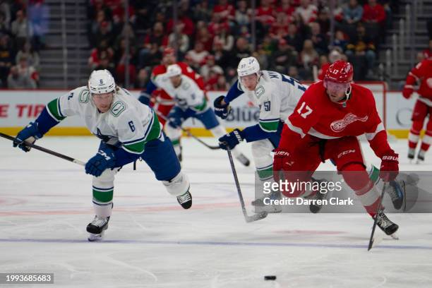 Daniel Sprong of the Detroit Red Wings battles for the puck Brock Boeser of the Vancouver Canucks during the first period at Little Caesars Arena on...