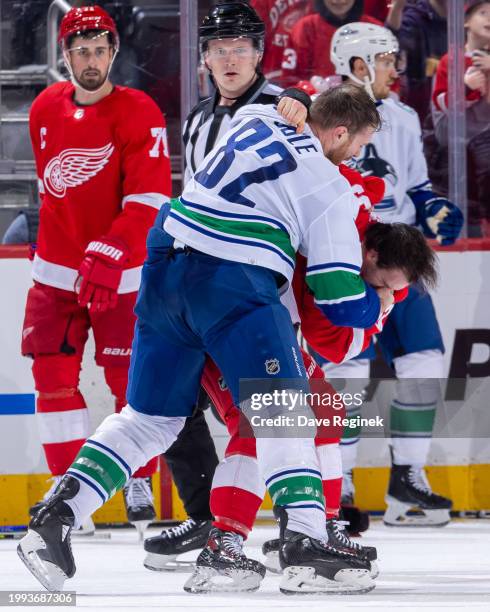 Alex DeBrincat of the Detroit Red Wings gets into a fight with Ian Cole of the Vancouver Canucks during the second period at Little Caesars Arena on...