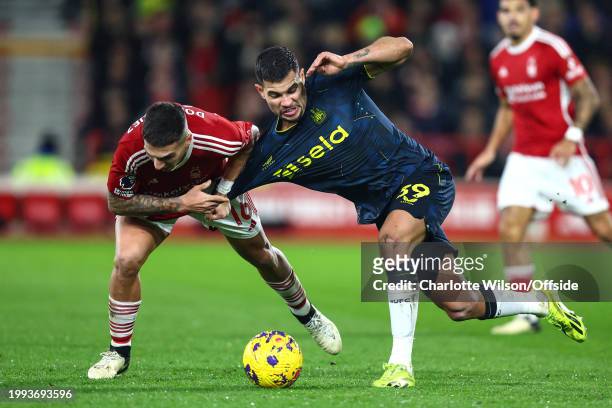 Nicolas Dominguez of Nottingham Forest pulls on the shirt of Bruno Guimaraes of Newcastle United during the Premier League match between Nottingham...