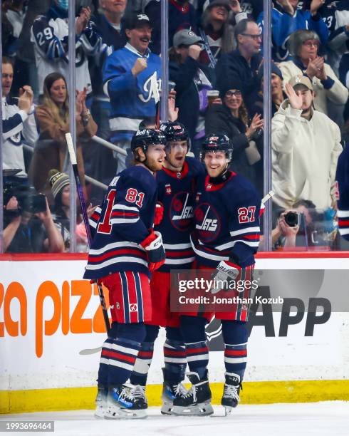 Kyle Connor, Mark Scheifele and Nikolaj Ehlers of the Winnipeg Jets celebrate a first period goal against the Pittsburgh Penguins at the Canada Life...