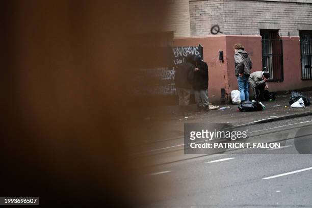 Erica Hetfeld looks on as people use fentanyl openly in the street in downtown Portland, Oregon on January 25, 2024. Hetfeld and her family moved out...