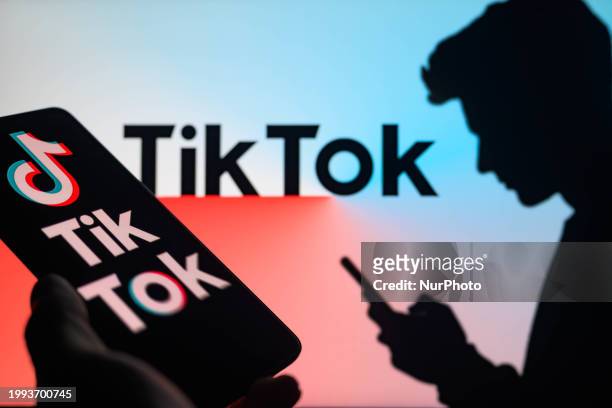 The TikTok logo is being displayed on a smartphone with TikTok visible in the background in this photo illustration in Brussels, Belgium, on February...