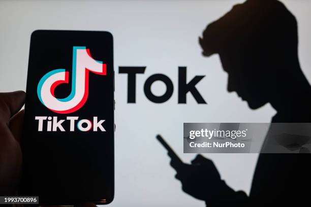 The TikTok logo is being displayed on a smartphone with TikTok visible in the background in this photo illustration in Brussels, Belgium, on February...