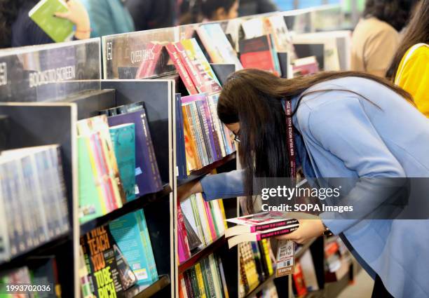 Visitor picks books at a book stall on the first day of the World Book fair 2024 with the theme "MULTI LINGUAL INDIA" A living Tradition, at Pragati...