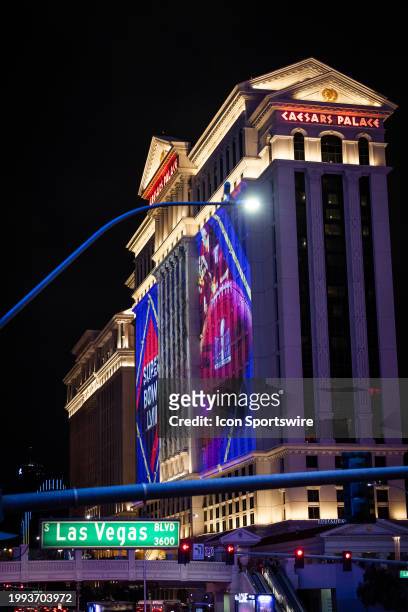 Caesars Palace Hotel & Casino with art projected on the side showing a graphic and a football with the Super Bowl LVIII logo with a Las Vegas...