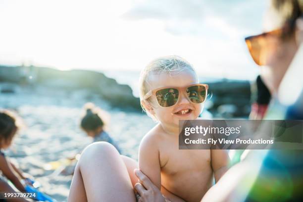 toddler boy wearing sunglasses on the beach - baby in sunglass stockfoto's en -beelden