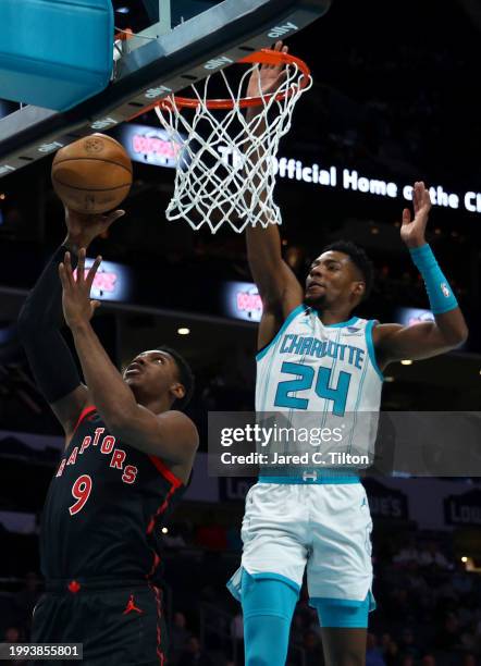 Brandon Miller of the Charlotte Hornets blocks a shot attempt fro RJ Barrett of the Toronto Raptors during the first half of the game at Spectrum...