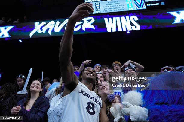 Quincy Olivari of the Xavier Musketeers takes a selfie with fans after beating the Villanova Wildcats 56-53 at the Cintas Center on February 07, 2024...